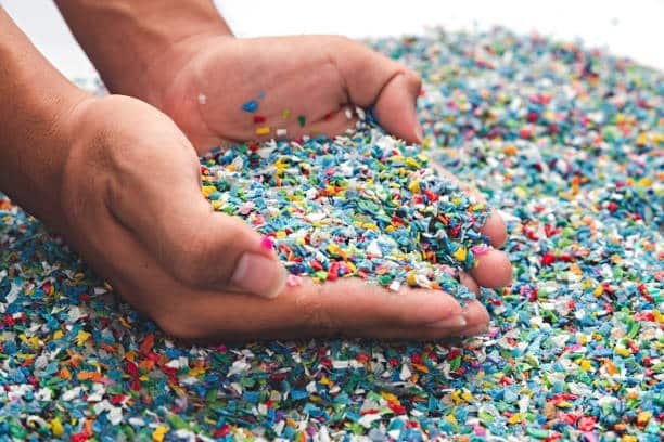 Colorful recycled plastic flakes representing mixed polypropylene and PVC waste materials