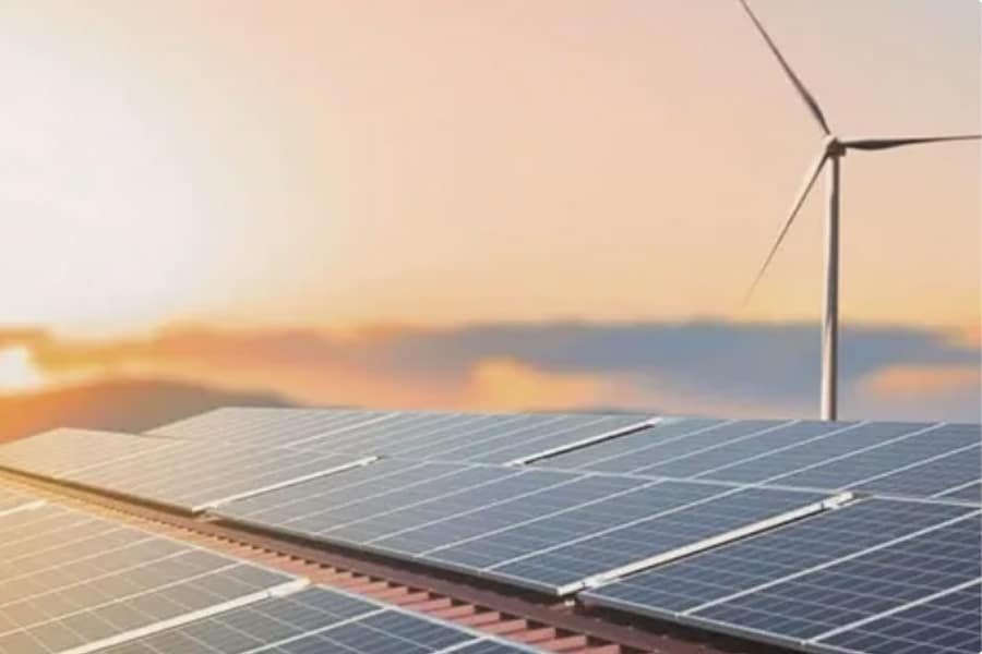 Solar panels on a rooftop with a wind turbine in the background, representing renewable energy systems and weatherproof component integration.