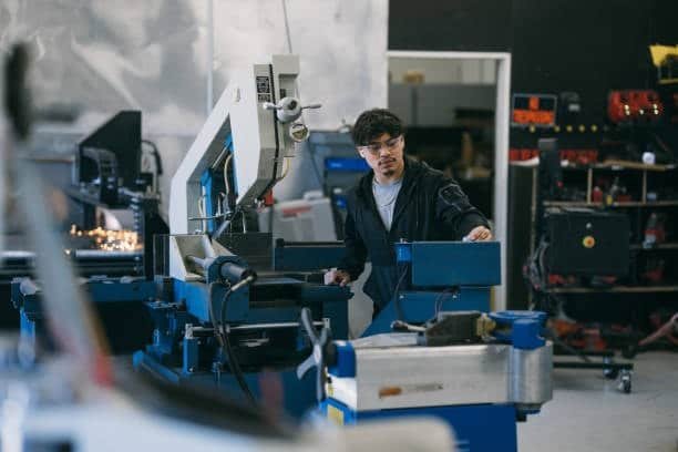 Swiss screw machine technician operating industrial equipment
