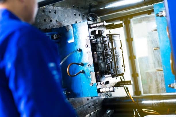 Technician setting up ABS injection molding machine for mold alignment