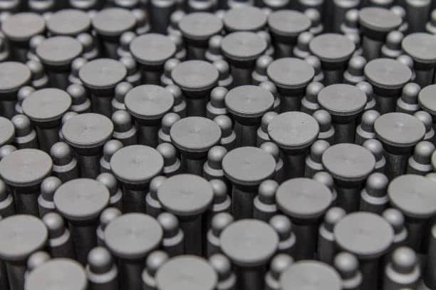 Textured matte-finish molded plastic parts arranged in uniform grid