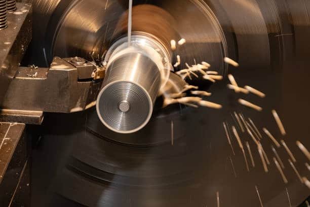 Lathe turning operation on a metal rod generating heat and chips without coolant