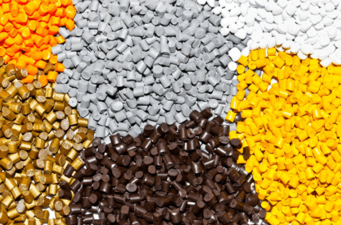 Different types of ABS plastic resin shown in brown grey yellow white and orange pellet form