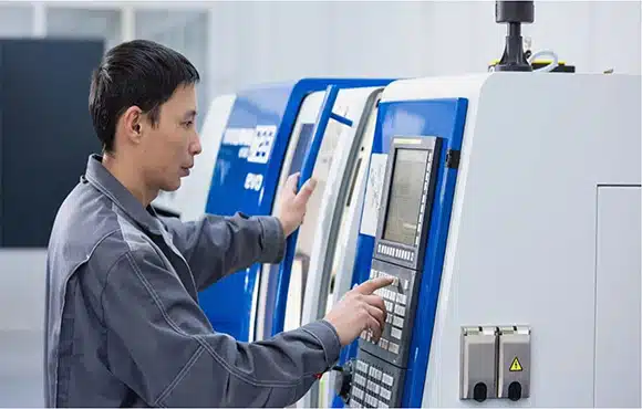An operator controlling an injection molding machine with a focus on precision and quality manufacturing.