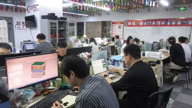 The design and engineering team working collaboratively in a modern office environment, focusing on customized injection molding projects.