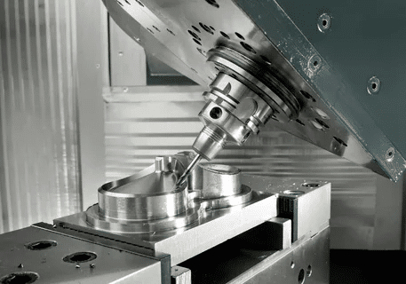 Angled CNC spindle machining complex metal part in 5-axis setup.