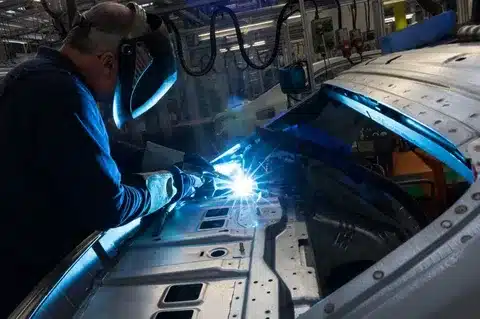 MIG welding sheet metal panels on a car body in an automated production line
