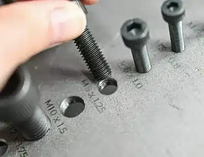 Bolt being inserted into tapped hole to verify correct thread size and alignment