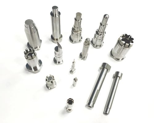 A selection of turned mold components, including collet-style and stepped shafts, with smooth finishes and precise diameters.