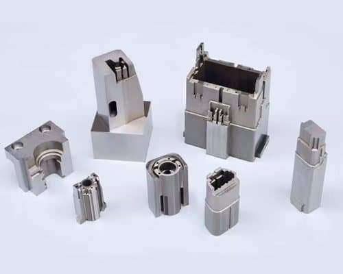 Assortment of custom precision-machined metal block components with complex geometries and tight tolerances.
