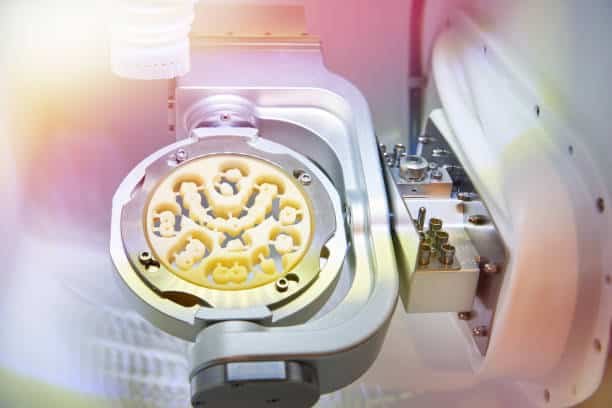 Close-up of a dental part being CNC machined using advanced milling equipment