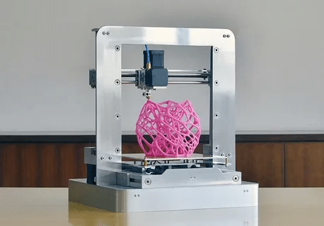 FDM 3D printer producing a geometric object using thermoplastic filament.
