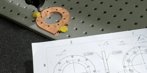 Geometric tolerance drawing used to guide inspection of machined part holes with probe.