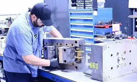Technician performing inspection and maintenance on an injection mould tool
