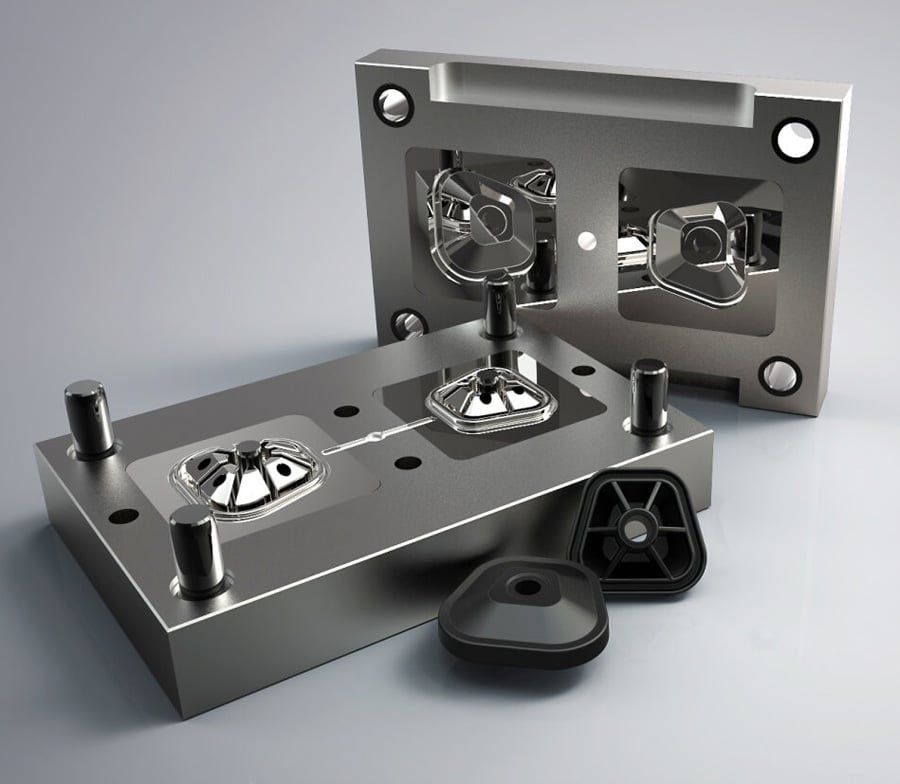 CNC-machined steel injection mold with two polished cavities and matching black triangular plastic foot supports in front.