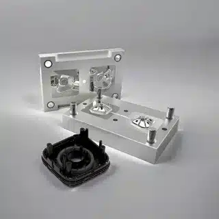 Open prototype injection mold with a black molded component for functional testing