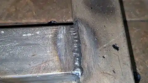 Close-up photo of poor weld quality at a steel corner joint with visible surface flaws