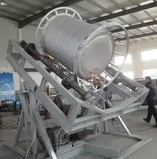 Biaxial rotational molding machine rotating large mold during production of hollow plastic components.