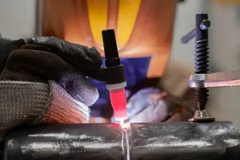TIG torch precisely welding a round tube on a metal fixture