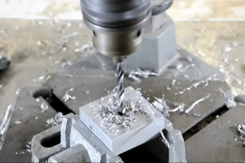 CNC machine milling aluminum part with chips being removed during process