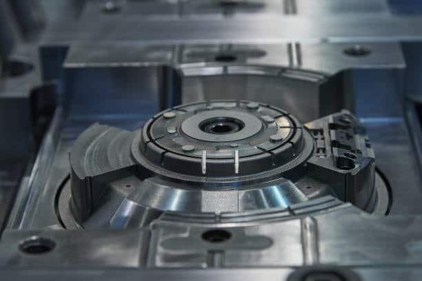 Detailed shot of circular mold component with complex features vulnerable to molding defects