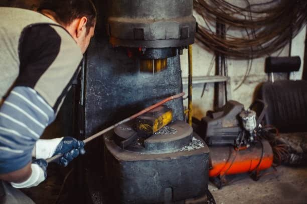 Heated steel bar being formed with a die under hydraulic forging machine