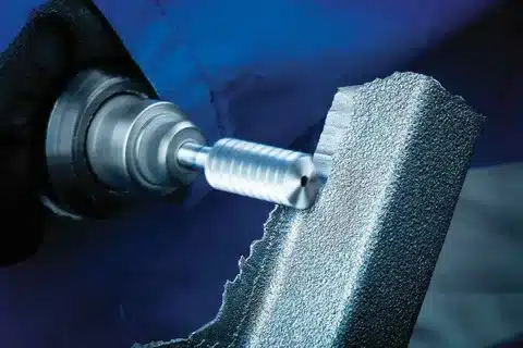 CNC deburring tool removing burrs from metal part for surface refinement