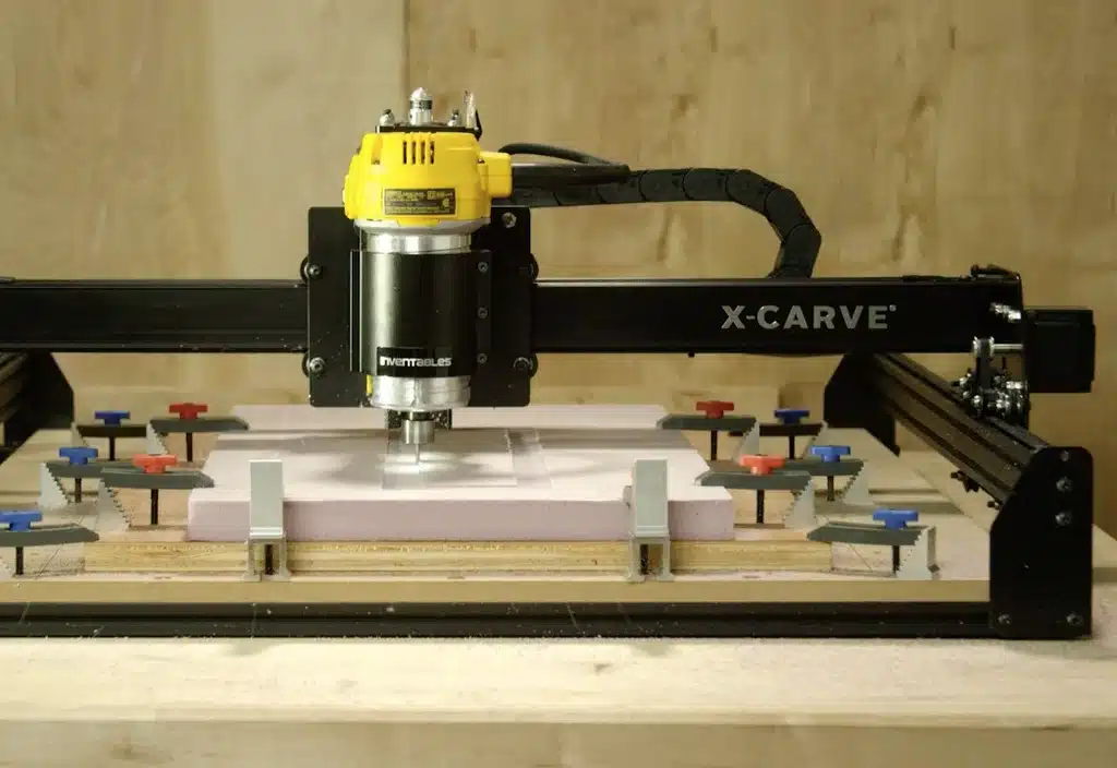 Foam sheet held by multiple clamps on CNC router during light milling
