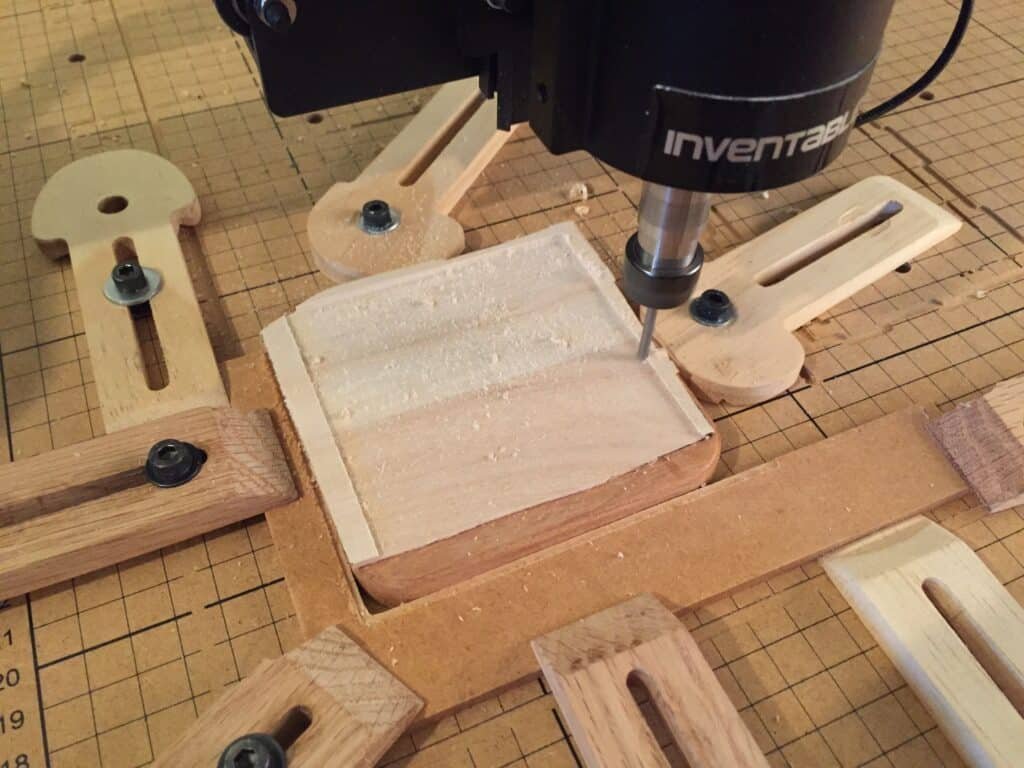 Wooden clamp system holding square wood block securely for CNC routing