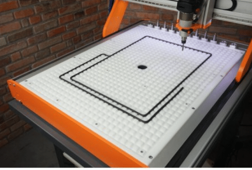 Vacuum table with grid pattern milled into pink foam board for CNC use