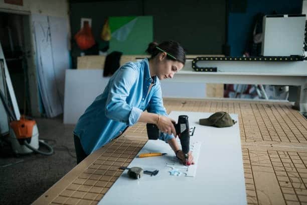 Female engineer using a heat gun to shape plastic materials
