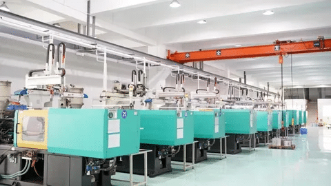 Row of automated injection molding machines in a clean manufacturing facility