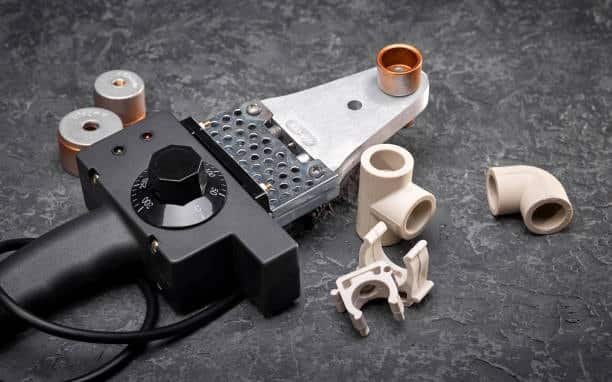 Insert molding tools and plastic fittings used in manufacturing pipe components