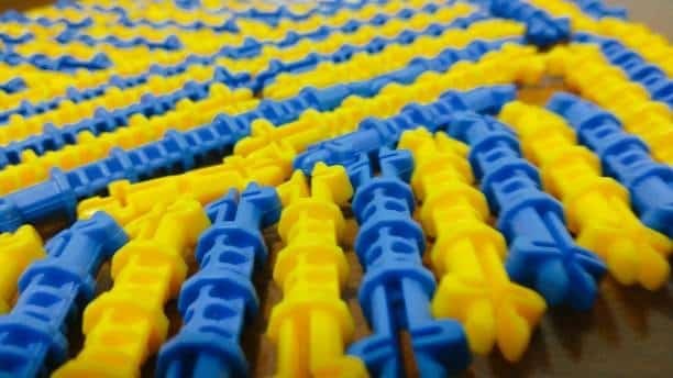 Plastic parts with contrasting yellow and blue pattern showing flow line transitions