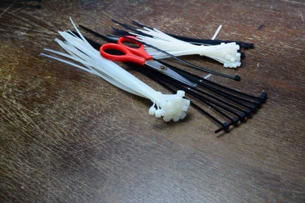 Nylon zip ties and scissors on a workbench, showing practical application of nylon plastic