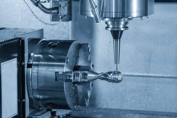 5-axis CNC machine with rotating table cutting intricate part profile