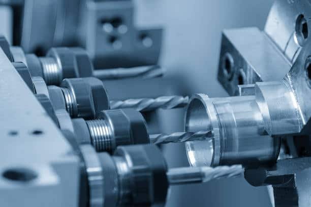 Swiss-style CNC machine with multiple cutting tools performing precise turning on metal part