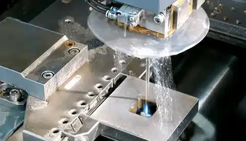 Wire EDM machine cutting workpiece with precision wire and dielectric flushing