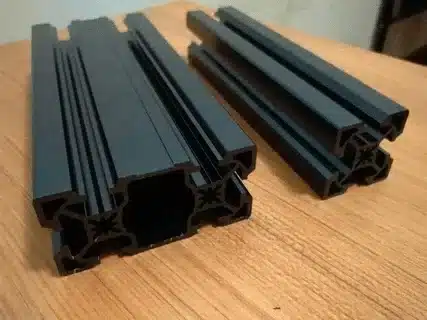 Close-up of black anodized aluminum extrusions with smooth finish.
