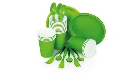Set of green disposable plastic tableware including cups, plates, and cutlery made from molded plastics.