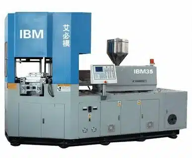 Industrial IBM injection blow molding machine for manufacturing plastic containers.