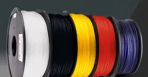 Colored PET plastic filament spools including black, white, yellow, red, and blue.