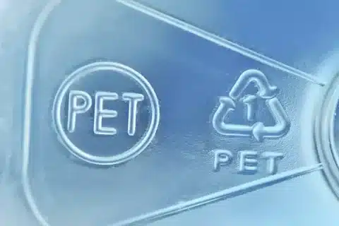 Close-up of PET recycling code with number 1 symbol commonly found on PET bottles and containers.