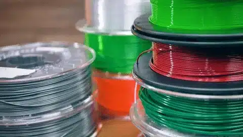Multiple spools of PETG filament in different colors used for 3D printing applications.