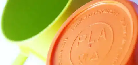 Close-up of a PLA plastic cup lid marked 100% biodegradable and safe