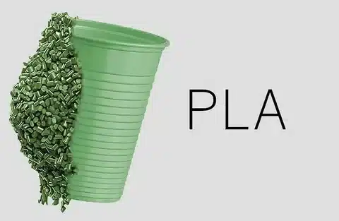 Concept image of PLA plastic cup half filled with green bioplastic pellets