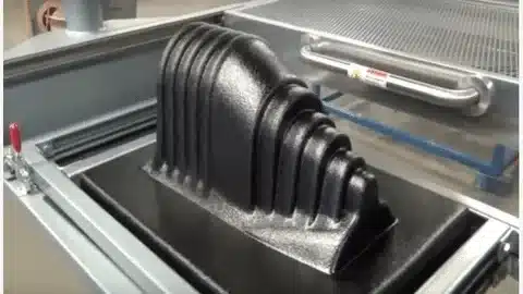 Large black ribbed plastic component made through vacuum forming technology.