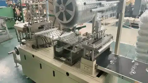 Factory vacuum forming equipment producing transparent plastic trays from continuous sheet rolls.