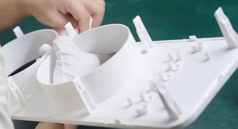 Injection molded part with flash defects being manually trimmed – example of poor mold design impacting production cost