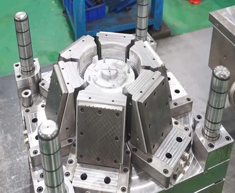 Multi-cavity rotary injection mold with central core and surrounding steel plates, designed for high-volume production.
